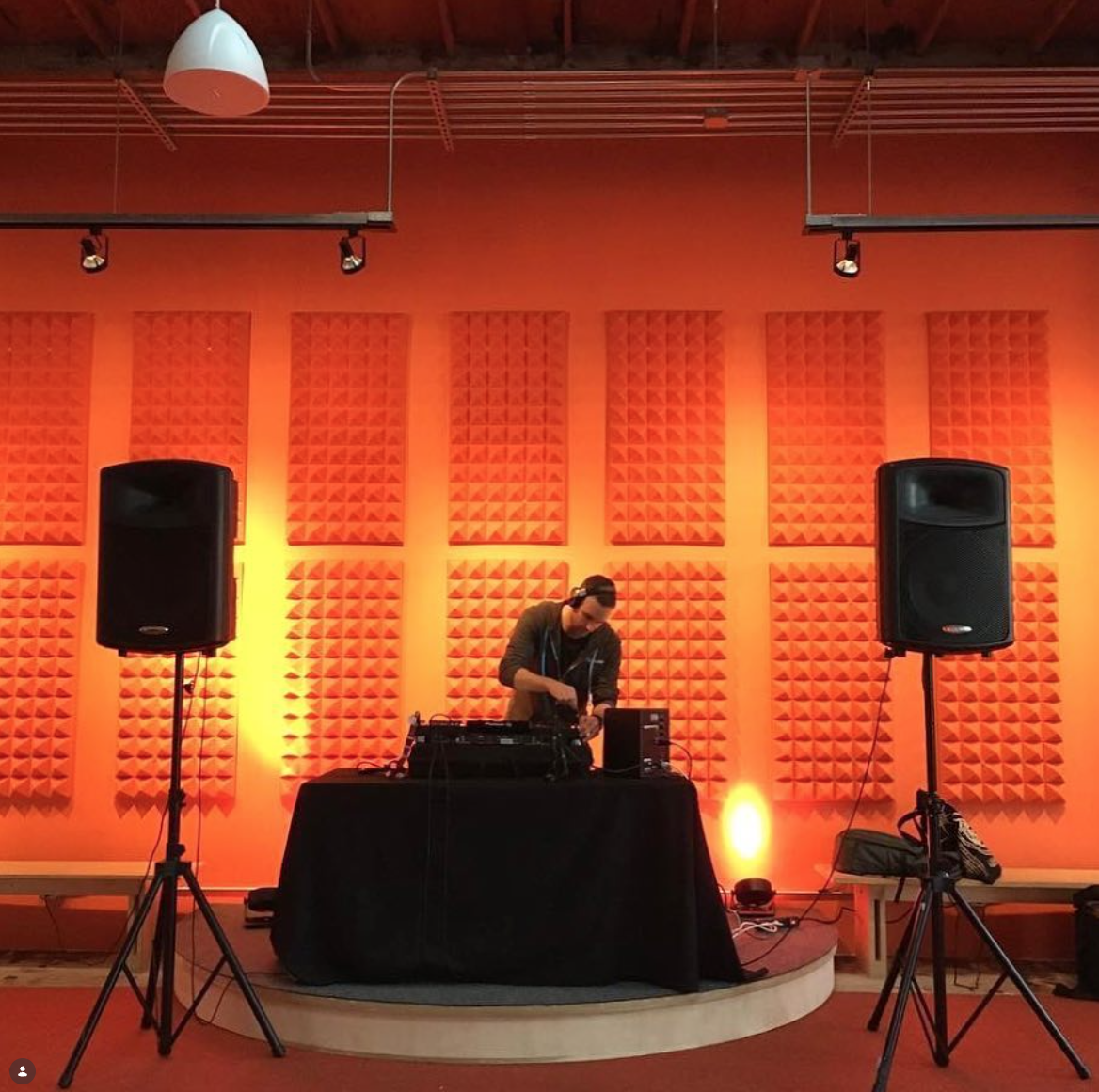 DJ set with orange acoustic backdrop