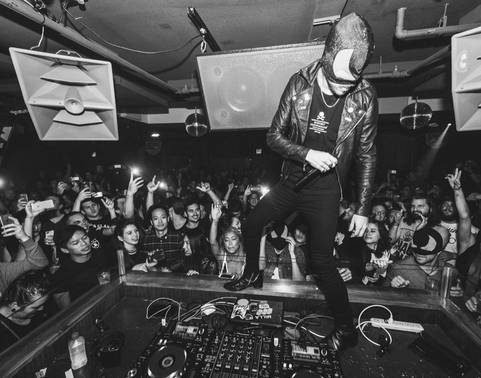 DJ performing on stage in front of a packed crowd