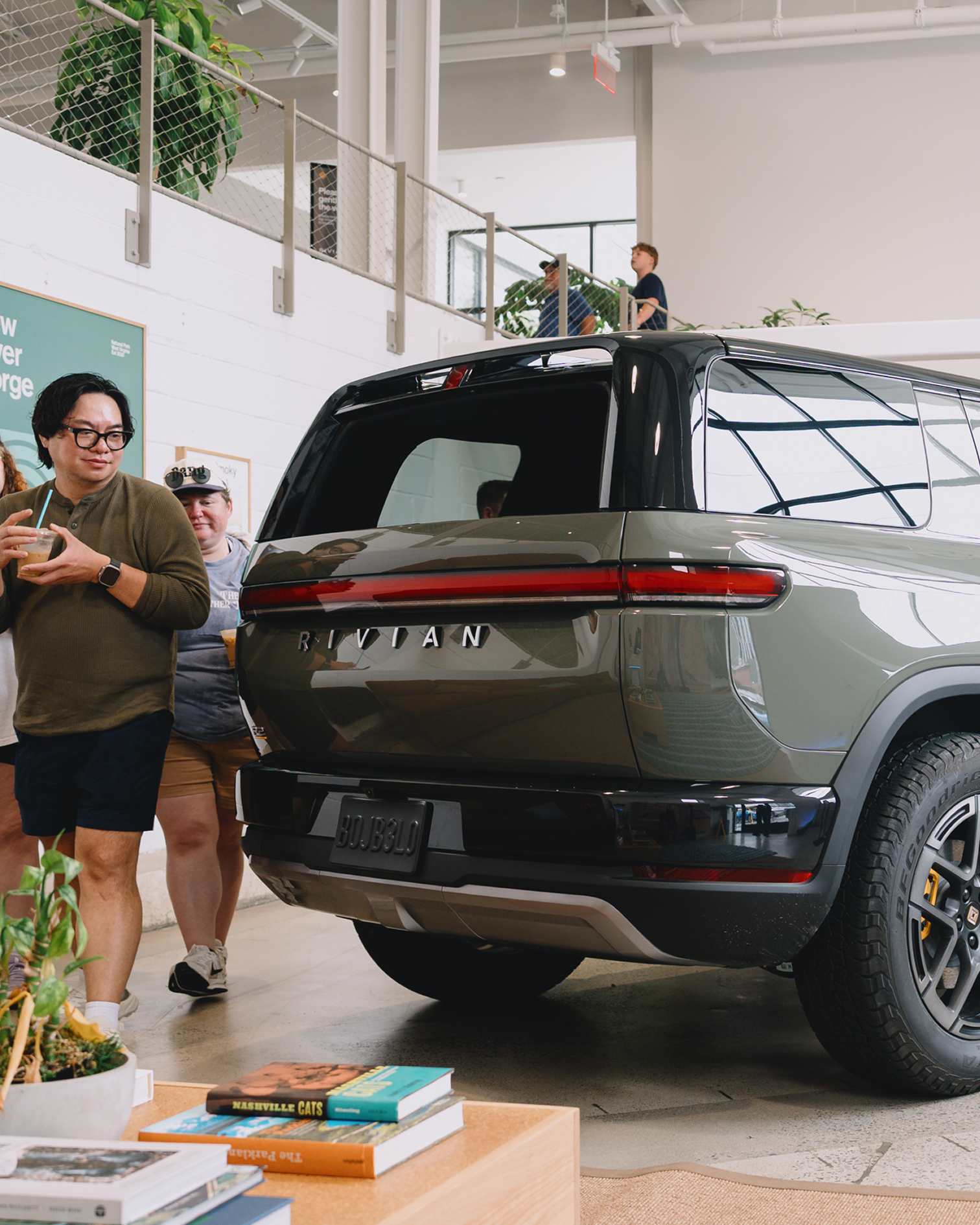 Guests viewing the Rivian R2 on display inside the showroom