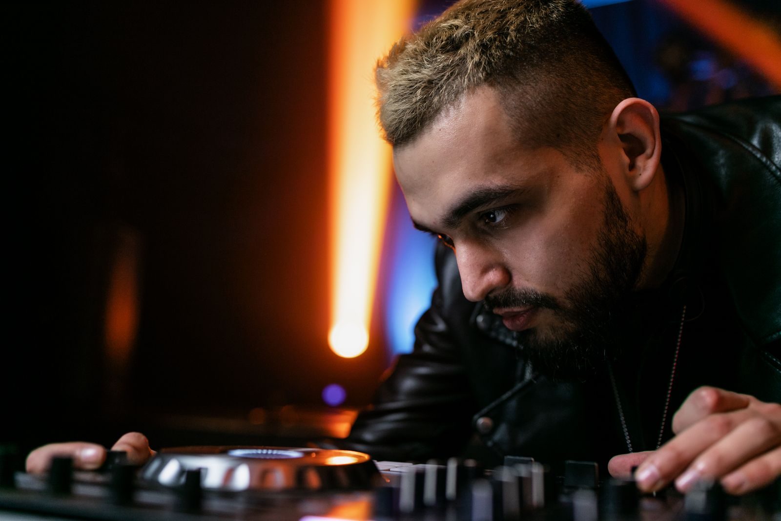 DJ concentrating at the decks under club lighting
