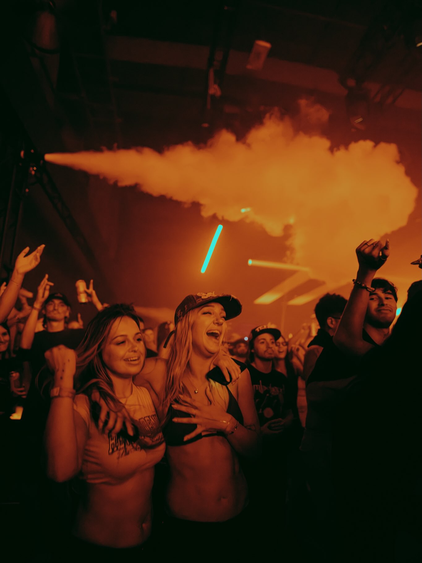 Crowd celebrating under red stage lighting