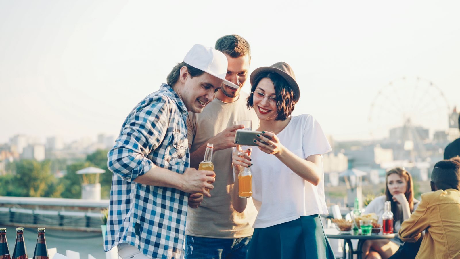 Founders mingling at a rooftop gathering with a city skyline behind them