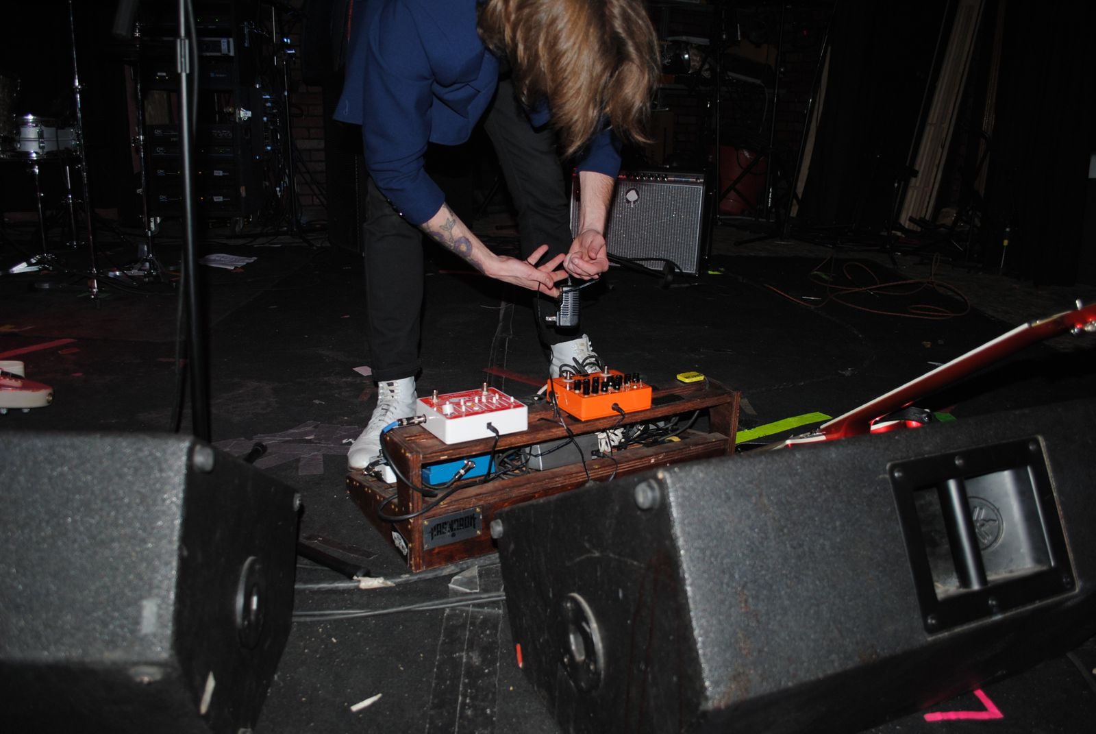 Crew working backstage behind the speaker stacks before a show
